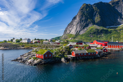 Obraz na plátně Aerial view shows red rorbuer on rocky islets by Reinebringen in Lofoten, Norway