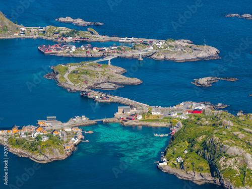 Fotografie Aerial scene shows red rorbuer, causeways, bridges, fishing boats, and docks in Lofoten, Norway