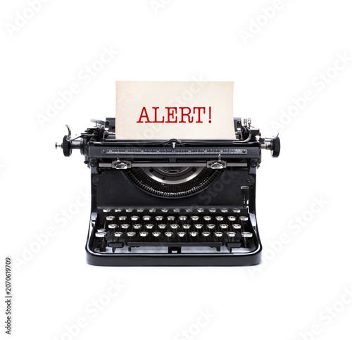 Alte analoge Schreibmaschine mit Briefblatt und der Notiz Alert