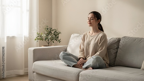 Young woman practicing yoga meditation at sunrise on peaceful mountain landscape