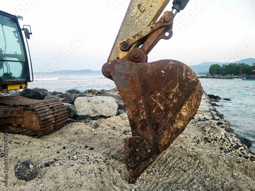 Fotografie Close-up of an old rusty excavator bucket showing weathered metal texture, corrosion, and industrial wear