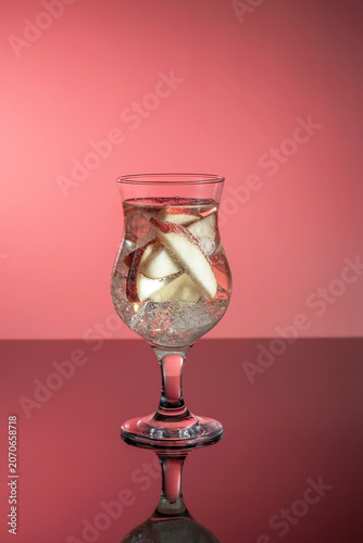 A glass of cocktail with mineral water and pieces of fruit, a healthy drink