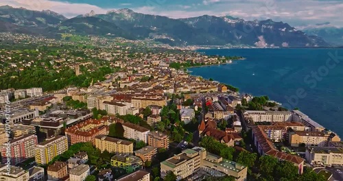 A Swiss town situated in the Alps and amidst green meadows. Establishing shot of Switzerland. Aerial view of Swiss