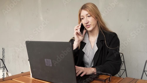 Young businesswoman multitasking talking on the phone