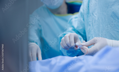 Fotografie Closeup of surgeon hands inserting catheter during cardiac procedure for clinica