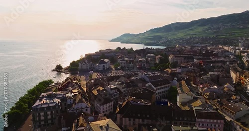 A Swiss town situated in the Alps and amidst green meadows. Establishing shot of Switzerland. Aerial view of Swiss