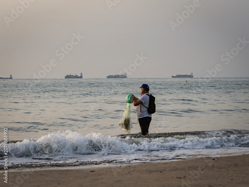 Fishermen on Pinedo beach (Valencia, Spain) at dawn