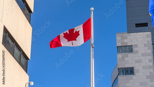 Vibrant Canadian flag waving against a clear blue sky