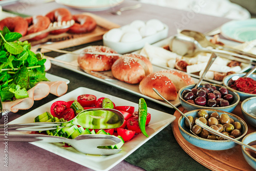 traditional turkish breakfast feast with rich variety on table photos series, fried dough pisi, green herbs, watermelon, cheese plate