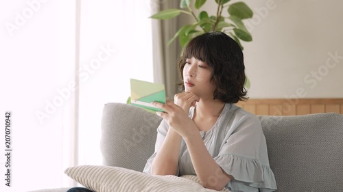 通帳を見ながら家計を考える女性, Woman Reviewing a Bankbook and Household Finances