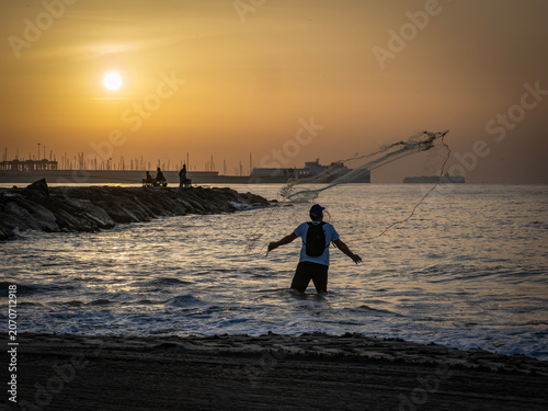 Fishermen on Pinedo beach (Valencia, Spain) at dawn