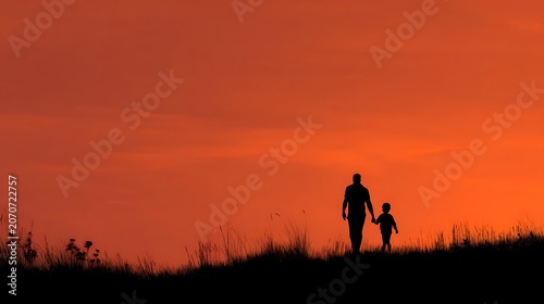 Silhouette of two people walking at sunset on a rural path