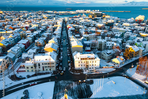 Winter aerial panorama of Reykjavík Iceland with snow covered streets colorful neighborhoods and the North Atlantic coastline viewed from above