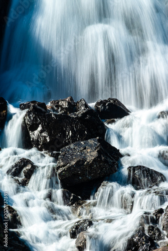 Close up of a cascading waterfall in Iceland with silky flowing water moss covered rocks and dramatic long exposure nature detail