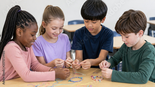 Children making friendship bracelets for classroom peace education