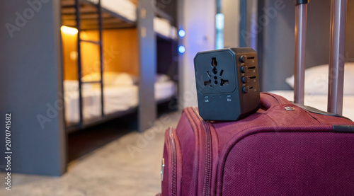 Foto Universal travel adapter rests on a suitcase beside a bunk bed in an urban hoste