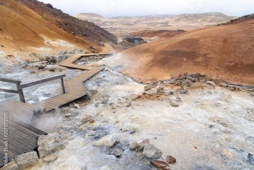 Wooden walkways help you cross the colorful geothermal area of Seltun in Reykjanes Peninsula in Iceland on a spring day