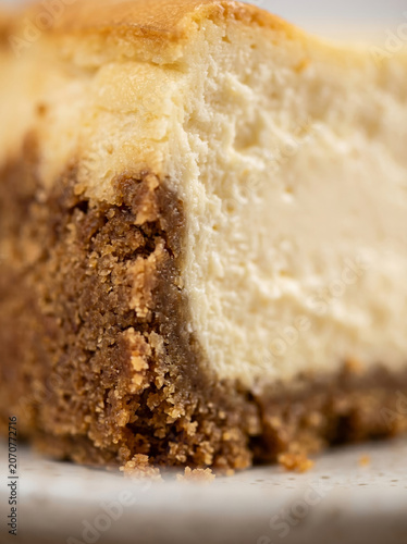 Slice of classic baked New York cheesecake texture closeup