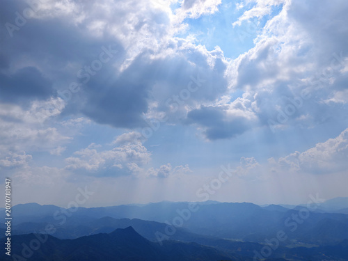 Sun Rays Over Blue Mountain Ridges and Cloudy Sky