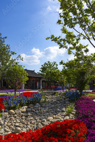 Colorful Chinese Garden with Flowers, Stone Path, and Traditional Pavilion