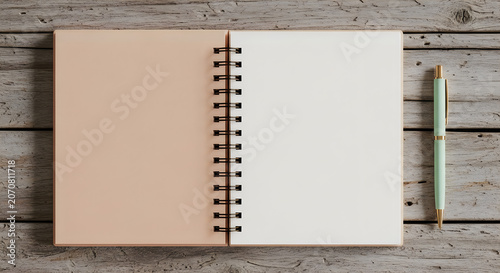 Open spiral bound notebook with blank pages and a pen on a wooden desk