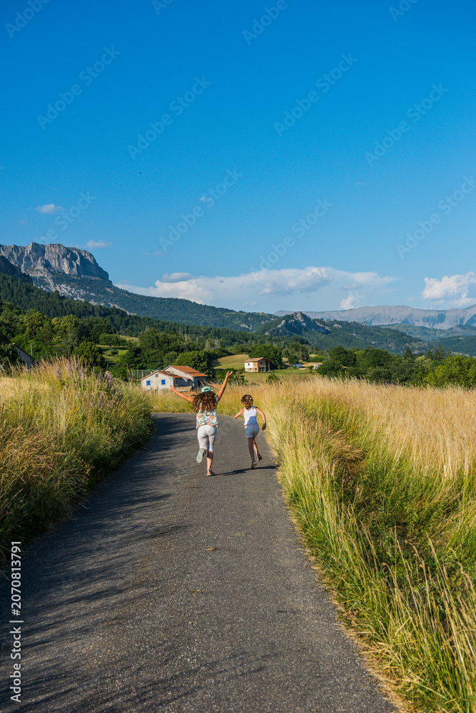 Obraz premium Children running on country road in provence mountains