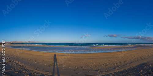 Photographer shadow on golden sand panorama of Sotavento beach lagoon Fuerteventura
