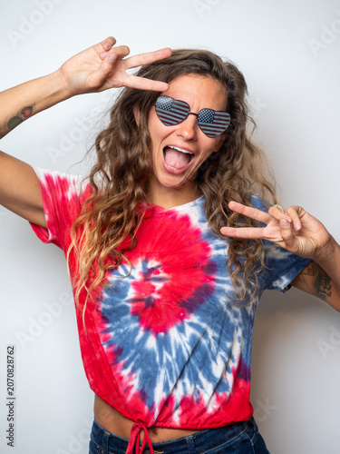Фотография Playful studio portrait of a woman against a clean white backdrop, open mouth smiling with peace signs