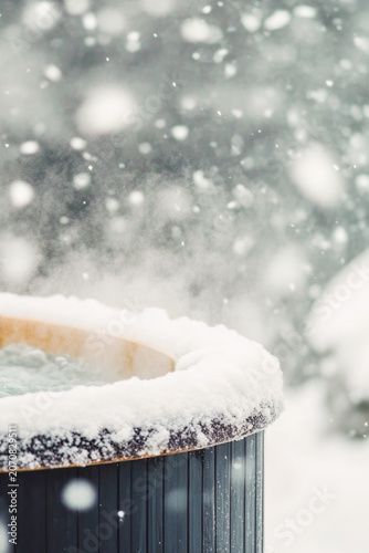 An outdoor hot tub surrounded by snow, perfect for winter scenes or cozy atmosphere vertical frame