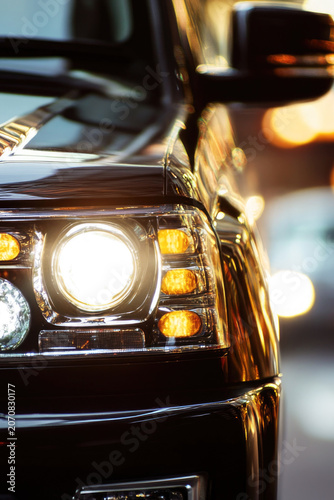 Close-up of car headlights on a city street at night vertical frame