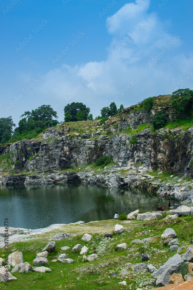 Fototapeta premium Sharp, white, marble-like rocky cliffs of Tarpania Lake, Marble Lake, Blue Dam, Patal Dam or Durga Bera,a scenic lake in the Ajodhya Hills of Purulia, West Bengal, India. Lake has Deep blue water.