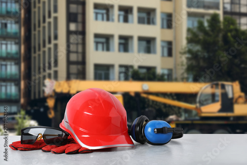 Fotografía Personal protective equipment on table against building site
