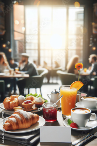 An atmospheric, hearty breakfast in the restaurant. A paper card and the blurred background provide copy space. Croissants, jam, orange juice, and cappuccino