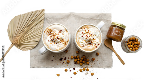 Two white cups of whipped cream coffee with caramel and nuts on a table transparent background