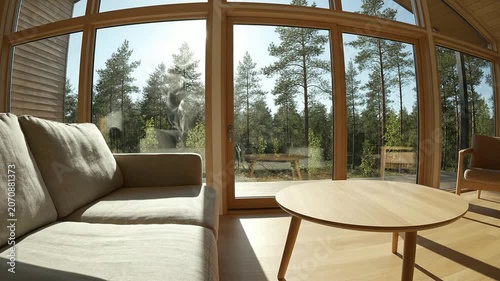 Sunlit Scandinavian Living Room With Large Windows Overlooking Forest And Modern Interior Design Details