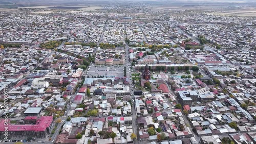 Aerial drone shot of the beautiful city of Gyumri in Armenia, showcasing its historic architecture, busy city squares, streets, and the famous landmark Holy Saviour's Church during autumn.

