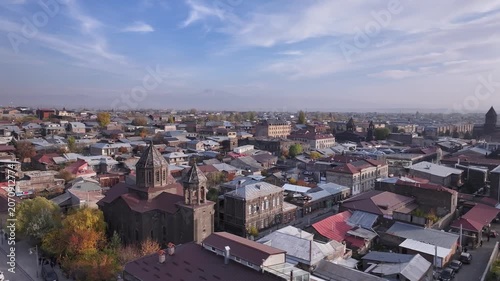 Aerial drone shot of the beautiful city of Gyumri in Armenia, showcasing its historic architecture, busy city squares, streets, and the famous landmark Holy Saviour's Church during autumn.


