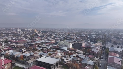 Aerial drone shot of the beautiful city of Gyumri in Armenia, showcasing its historic architecture, busy city squares, streets, and the famous landmark Holy Saviour's Church during autumn.

