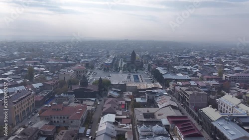 Aerial drone shot of the beautiful city of Gyumri in Armenia, showcasing its historic architecture, busy city squares, streets, and the famous landmark Holy Saviour's Church during autumn.

