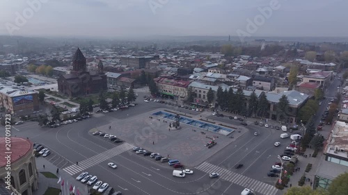 Aerial drone shot of the beautiful city of Gyumri in Armenia, showcasing its historic architecture, busy city squares, streets, and the famous landmark Holy Saviour's Church during autumn.

