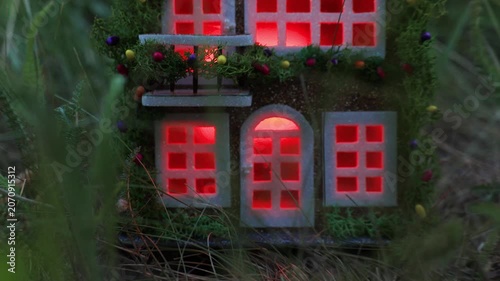 Among the dense greenery there is a fairytale decorated house with color-changing light in the windows