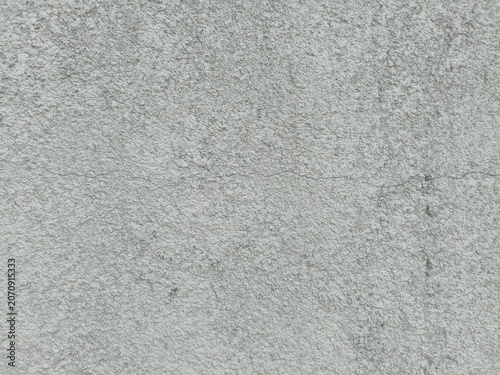 Close-up of a textured grey concrete wall with a fine crack, construction background.