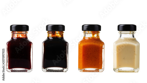 Konstfotografi Isolated studio shot of four small bottles filled with various sauces and condiments