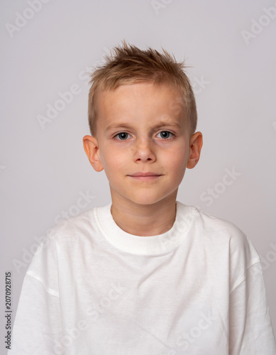 Studio shot of a smiling young boy looking at camera Casual portrait of a handsome school-age boy