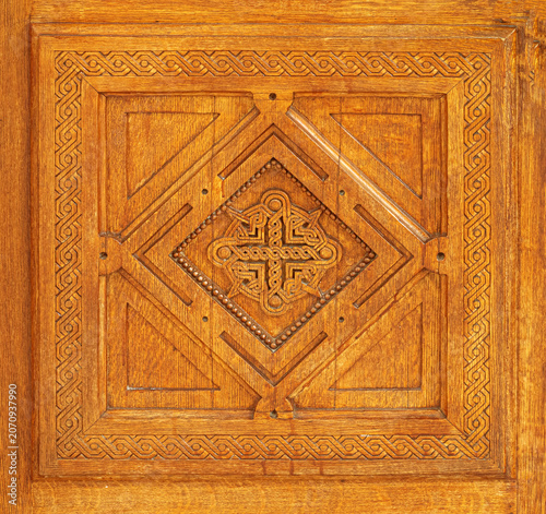 Carved wooden panel displaying celtic cross pattern and knotwork border