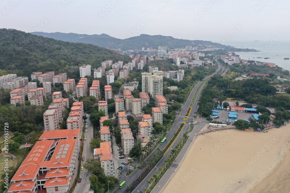 Obraz premium Beachfront Residential District with Elevated Highway and Sandy Shore