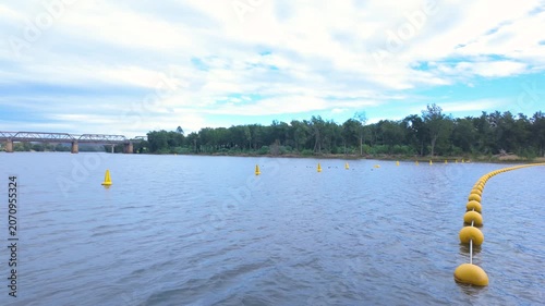 Footage of yellow safety buoys running across the Nepean River to signal to marine vessels and swimmers to stop from running over the nearby Penrith Weir in New South Wales, Australia