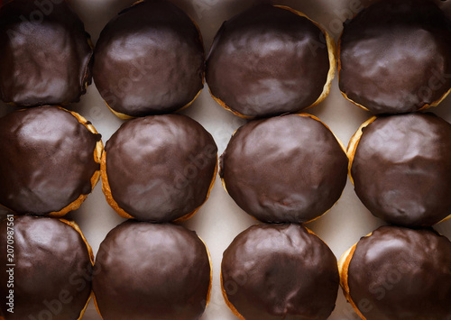 Set of donuts with chocolate icing on paper, donut background. Sweets, dessert and pastry, close up, top view