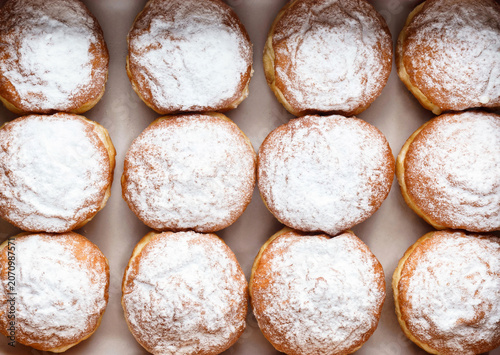 Set of donuts with vanilla and powdered sugar on paper, donut background. Sweets, dessert and pastry, close up, top view