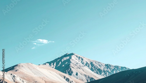 Majestic mountain peak under a clear blue sky in a scenic landscape.
